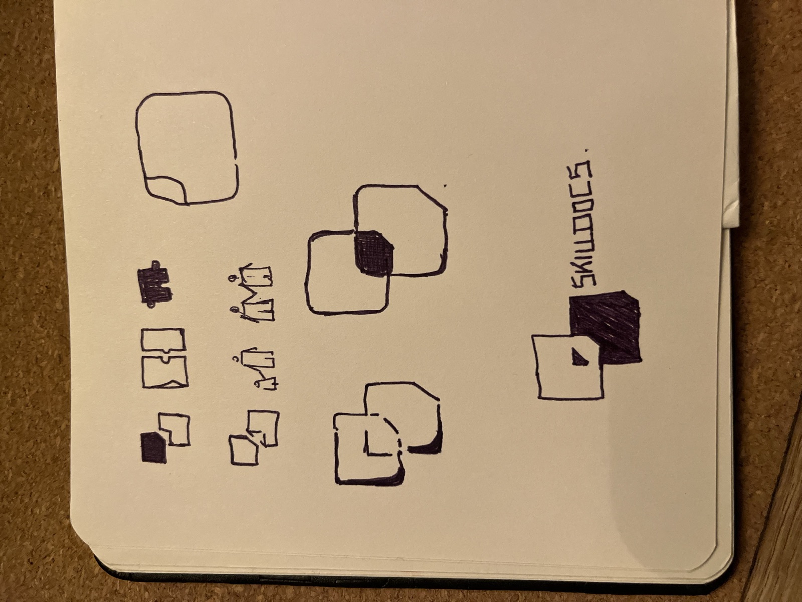 Notebook page of hand-drawn explorations of the SkillDocs logo
